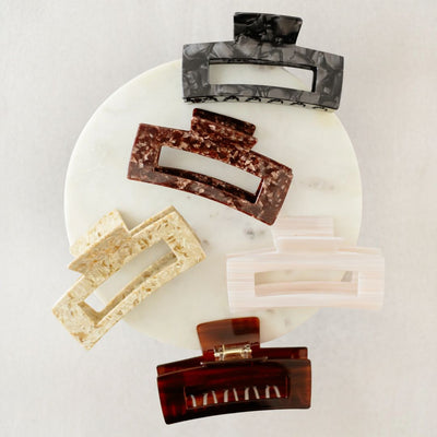 Set of marble-patterned hair clips on a white marble surface