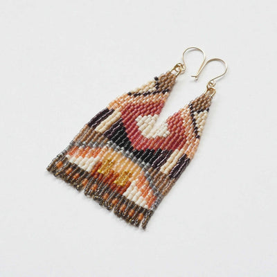 A pair of long, triangular tapestry-style earrings hand-stitched with small Japanese glass beads in a warm, geometric pattern featuring shades of cream, tan, rust, coral, burgundy, brown, and black. They hang from delicate 14 KT gold filled fishhook ear wires.