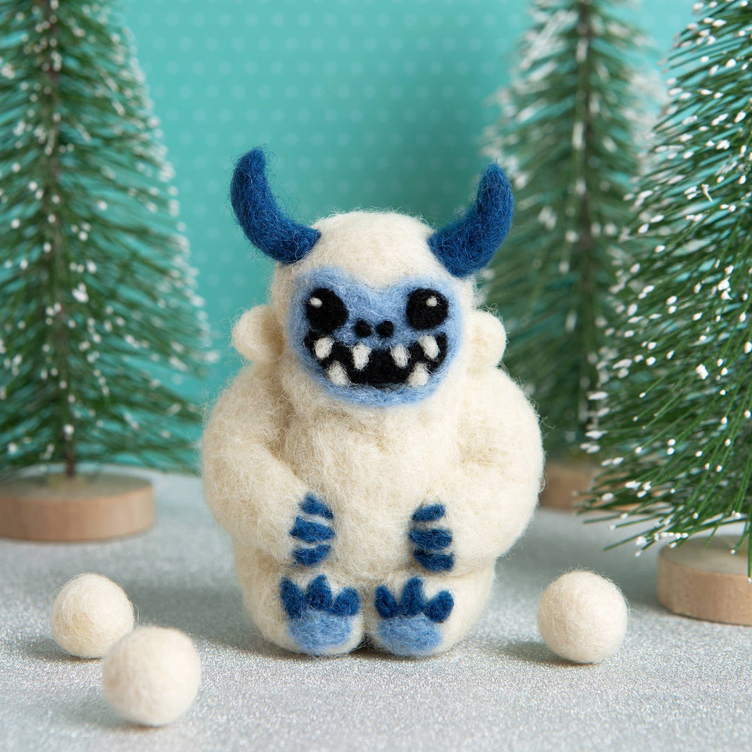White creature with blue accents in a snowy landscape with trees