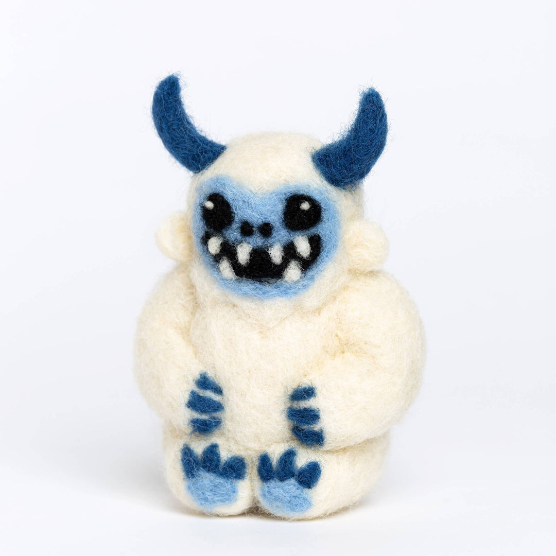 Small plush toy with blue accents on a white background