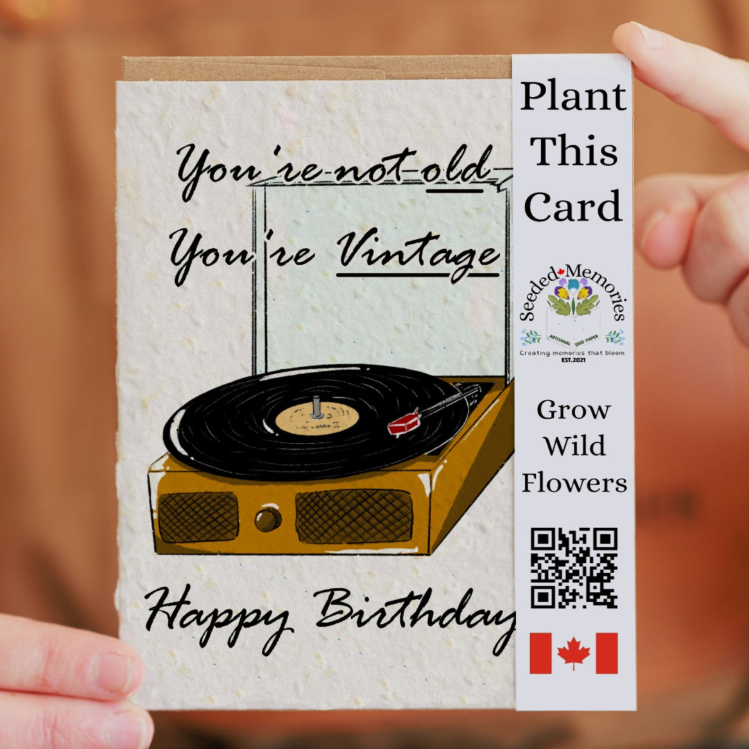 Birthday card with a record player illustration and text 'You're not old, you're vintage' held by a hand.