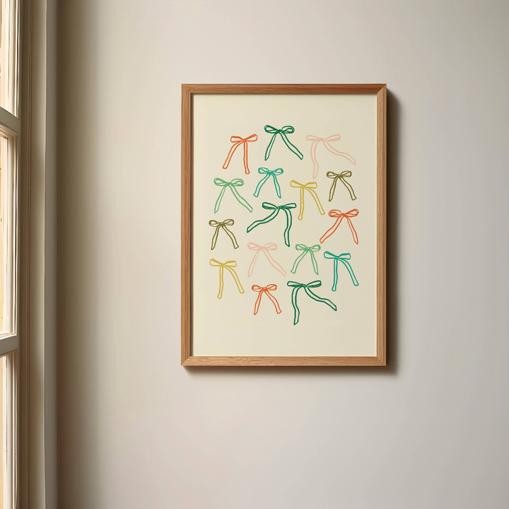 Colourful Bows Art Print in a wood frame hanging on a wall next to a window.