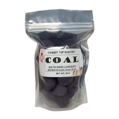 Bag of coal-shaped bath bombs with a label on a white background