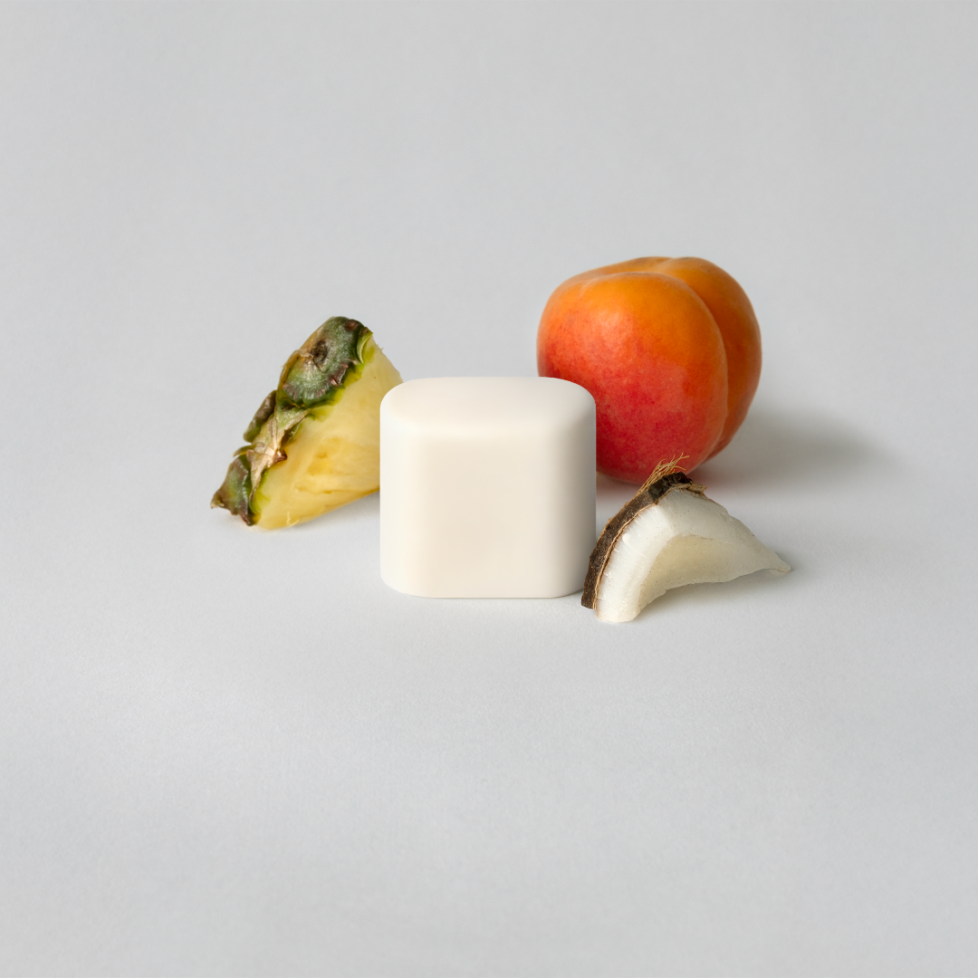 Fruit slices including a pineapple, apple, and banana on a light gray background