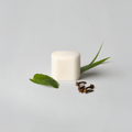 White cube with green leaves on a light gray background