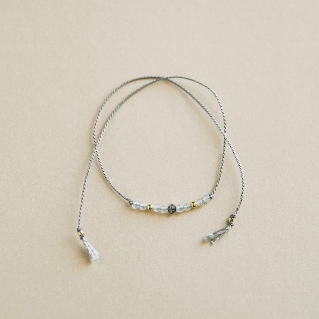 Thin beaded necklace on a beige background