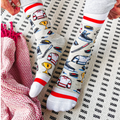 A pair of crew socks featuring a hockey theme. The socks are mostly grey with white and red stripes at the top and bottom. The design includes hockey-related icons like a trophy, skates, and a puck. The text "Hockey Dad" is printed on the socks.