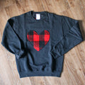 A black sweatshirt with a large, red and black buffalo plaid heart design in the center. 