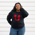 A black sweatshirt with a large, red and black buffalo plaid heart design in the center. 