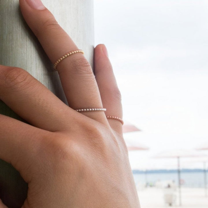 Delicate gold and silver rings with a row of small beads.
