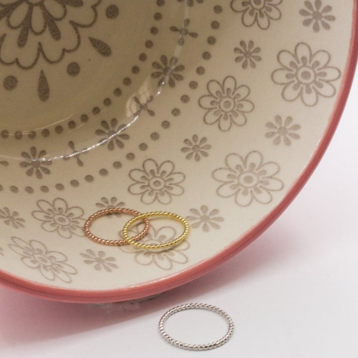 Delicate gold and silver rings with a row of small beads.