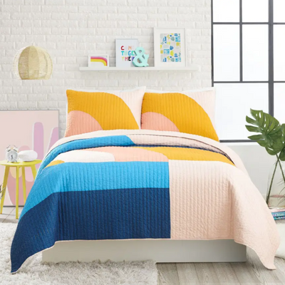 A bedroom with a colourful quilt set.