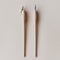 Two wooden calligraphy tools with examples of tips for writting.