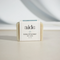 A bar of Aide Bodycare Eucalyptus Mint Soap, featuring a light beige color and a paper label with the 'aide' logo and 'Eucalyptus Mint' text, displayed on a light-colored surface with a shadow overlay. The soap is natural and handmade, available in Mississippi Mills, Ontario, Canada.