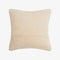 The back of the pillow in cream coloured fabric.
