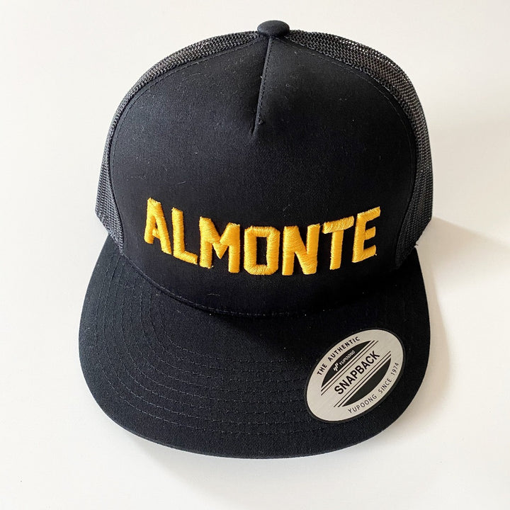 Black trucker hat with Almonte embroidered in gold on front