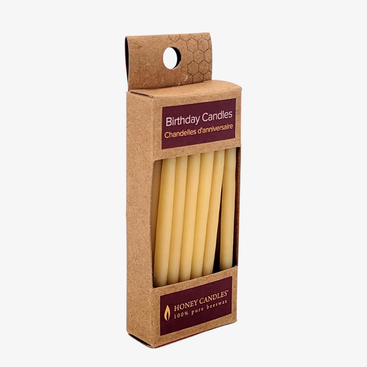 A cardboard box containing 10 yellow beeswax birthday candles. The box has a label that says 