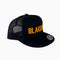 A black trucker hat with the word Blakeney embroidered across the front in golden yellow thread.