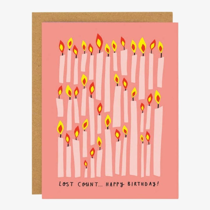 A pink card covered in lite candles and quote 