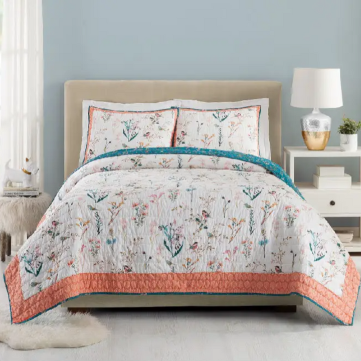 An image of a bedroom with a floral quilt.