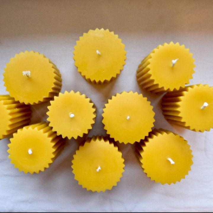 An above view of several fluted beeswax pillar candles.