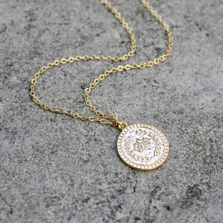 A gold coin necklace with a crown by Vintage Acorn