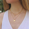 Woman wearing 3 layered Vintage Acorn gold necklaces. 
