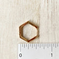 The Gold Hexi Huggies close up image Made from brass- plated with 18k gold. Nickel free and safe for sensitive ears. Measures about a half inch.