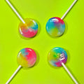 A close-up image of a pile of colorful, round lollipops on sticks. The lollipops have a swirling pattern of pink, blue, and yellow colors.