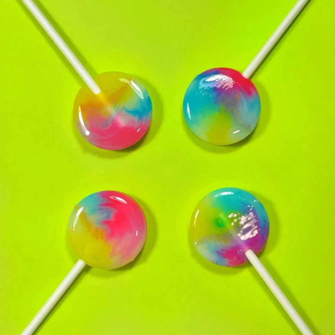 A close-up image of a pile of colorful, round lollipops on sticks. The lollipops have a swirling pattern of pink, blue, and yellow colors.