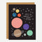 A black card with cartoon planets and the quote 