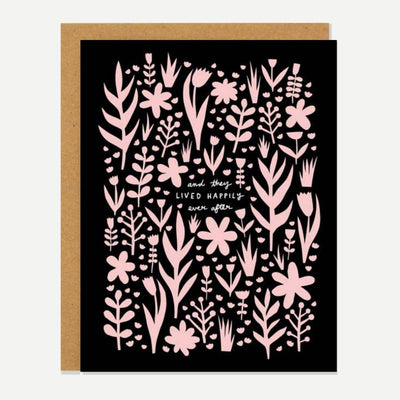 A black card with pink flowers and quote 