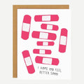 A white card with pink bandages and quote "I hope you feel better soon".