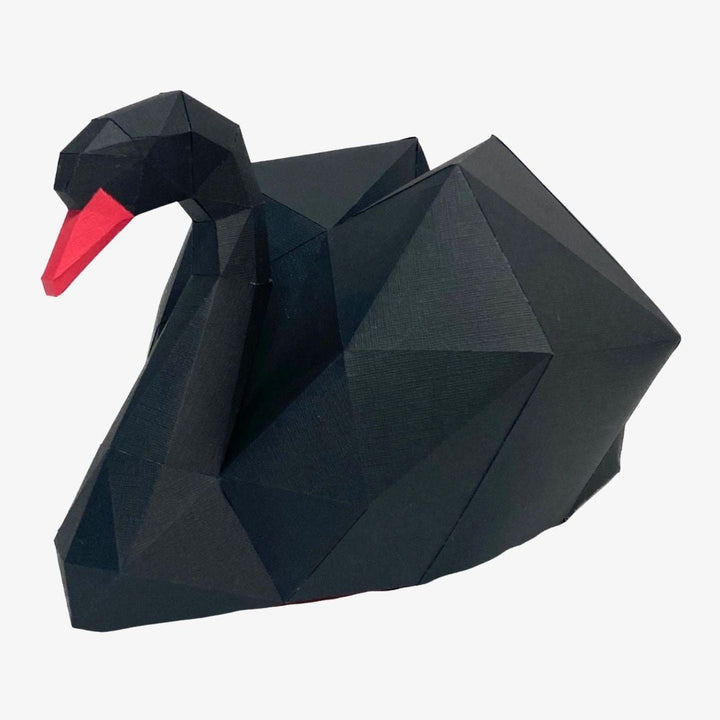 a black paper swan with a red beak
